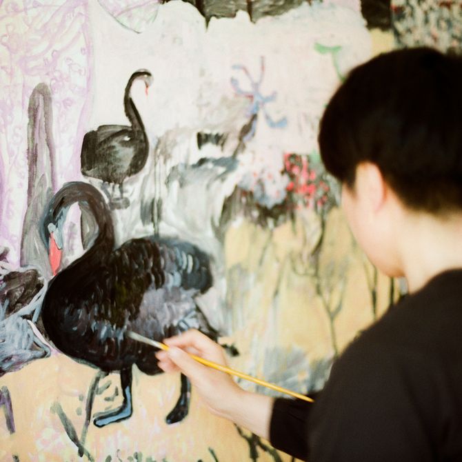 Close-up of artist painting a black swan on a canvas