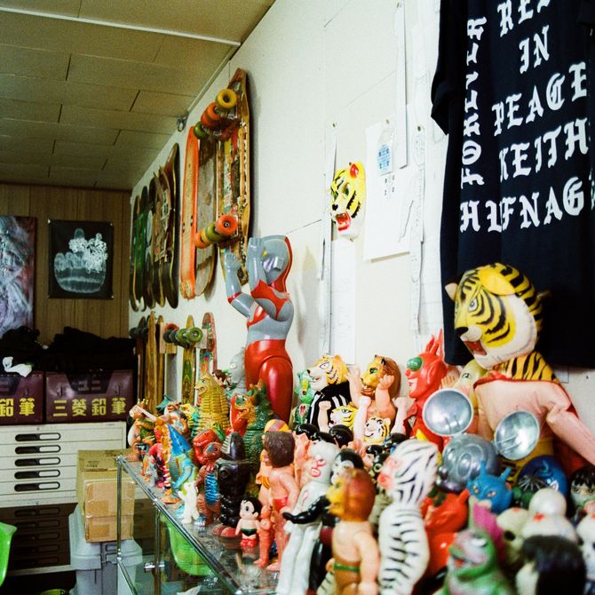 shelves of figurines and merchandise on the walls of Haroshi's studio