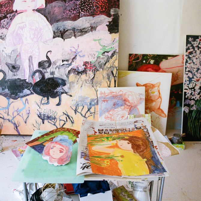 paintings and drawings on the floor of the studio