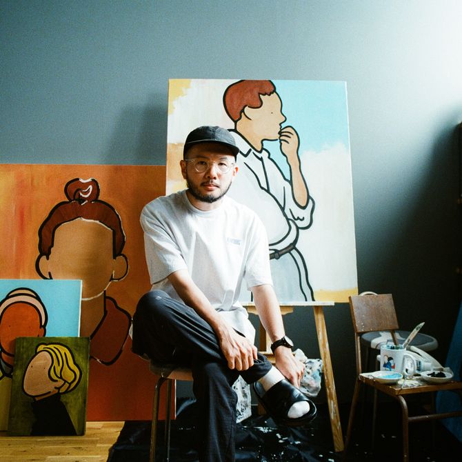 Rooo Lou sitting on a chair in his studio