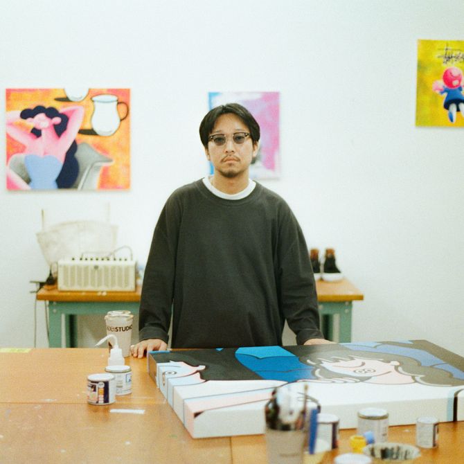 Face Oka standing behind a desk in his studio