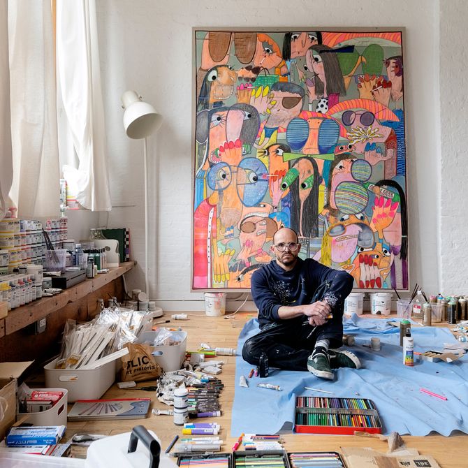 Rafa Macarron sitting in his studio surrounded by paints and materials
