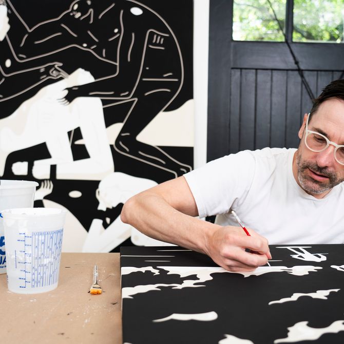 Cleon Peterson working on a monochrome painting on a work surface