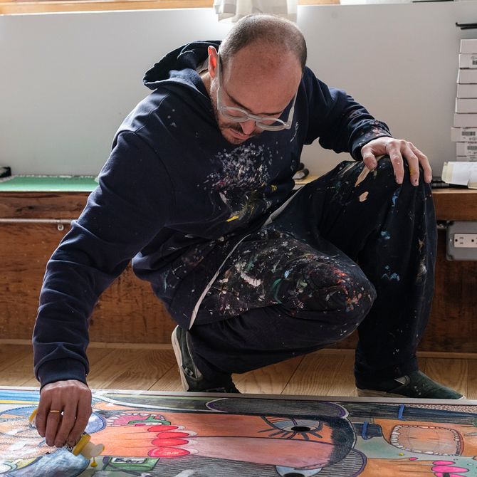 Rafa Macarron kneeling to add paint to a canvas