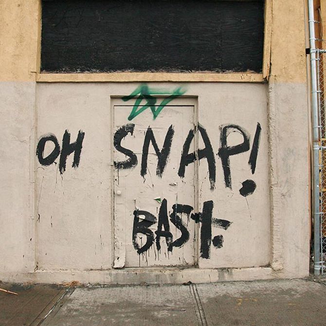 'OH SNAP BAST' painted on a cream wall/door in black
