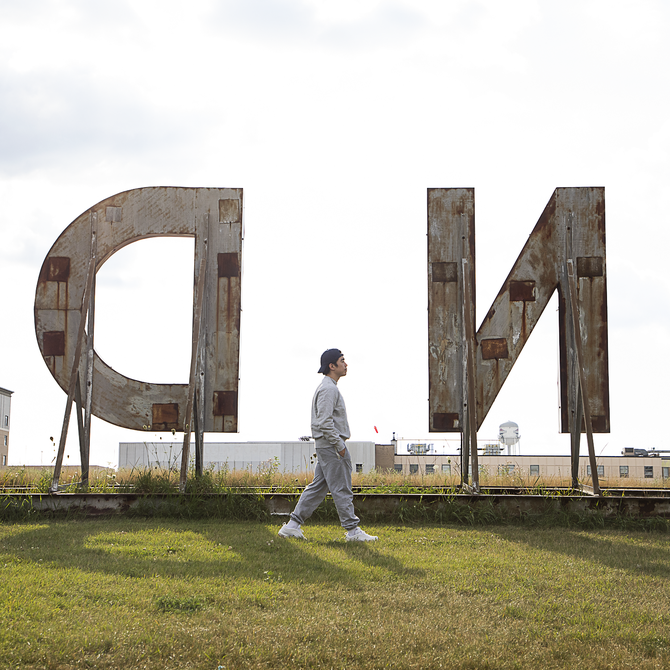 Grant Riven Yun walking in front of large letters