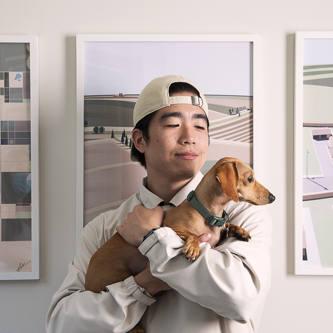 Grant Riven Yun holding a dog in his studio