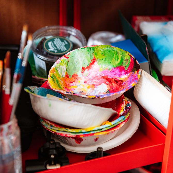 a stack of paint-covered paper bowls