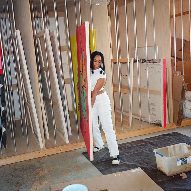 Tschabalala Self moving a large red painting in her studio