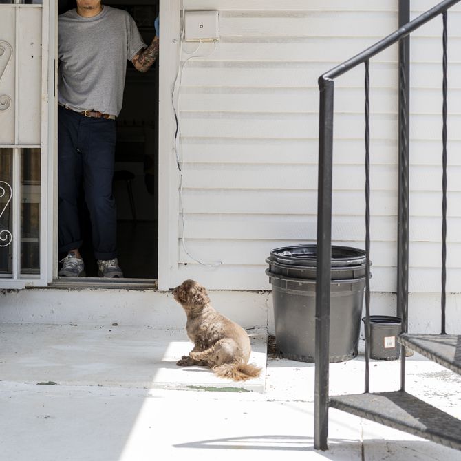 Koichi Sato outside his house with his dog