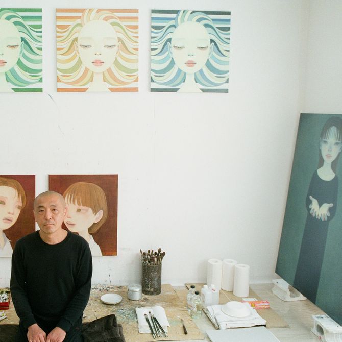 Hideaki Kawashima sitting in his studio with materials and prints