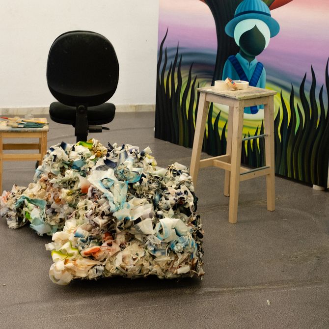 A pile of used masking tap in front of two chairs and a canvas