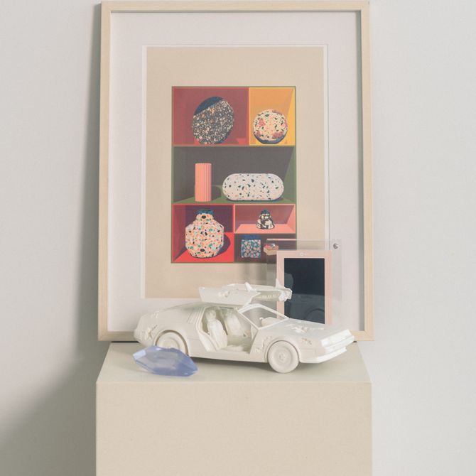 framed print, white model car and pale blue crystal on a white side table