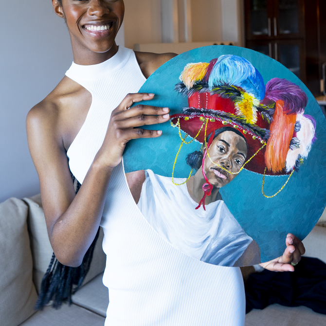 Ekene Maduka wearing a white dress and smiling as she holds up a tondo portrait painting 