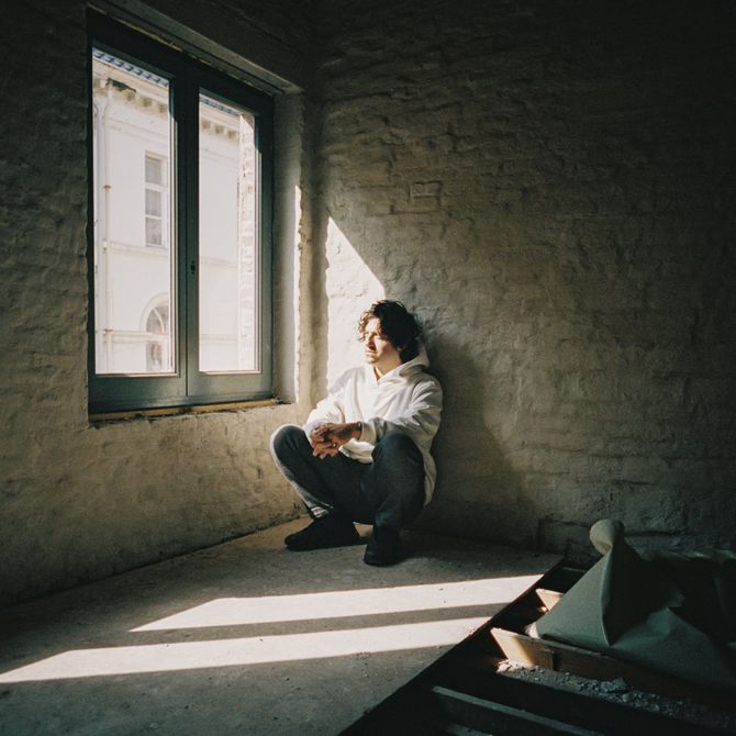 David Rudnick squatting in the corner of his new, half-build studio space in Ghent.