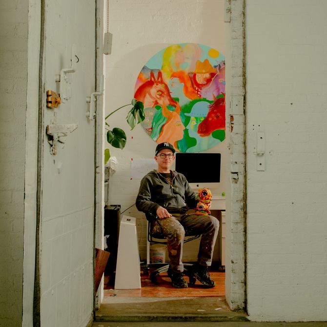 Aaron Johnson sits in studio with sculpture
