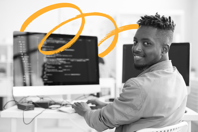 Web developer smiling at desk while coding