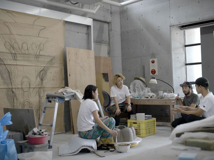 four artists sat in a studio chatting