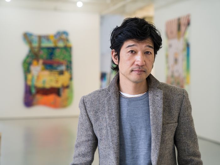 artist Tomokazu Matsuyama standing in his studio and looking to the camera