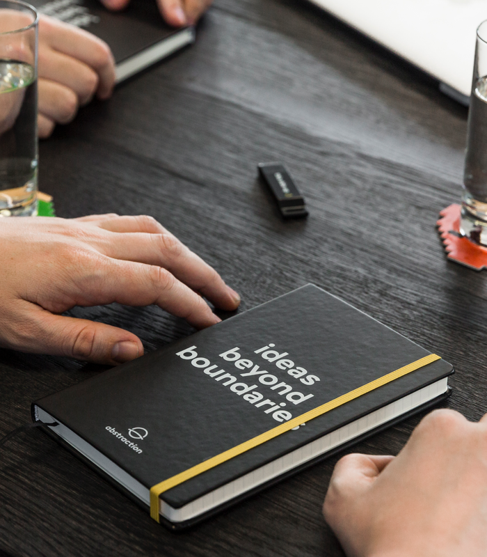 Abstraction notebook with the text 'ideas beyond boundaries' during a meeting.