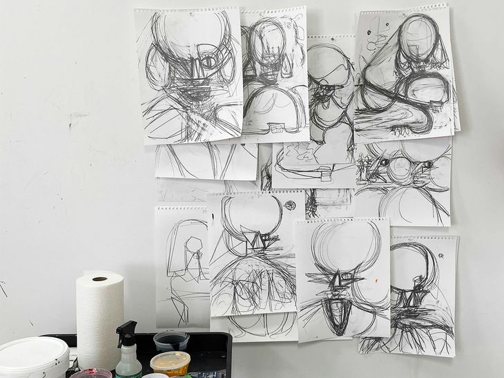 a collection of sketches of poodles pinned to a studio wall