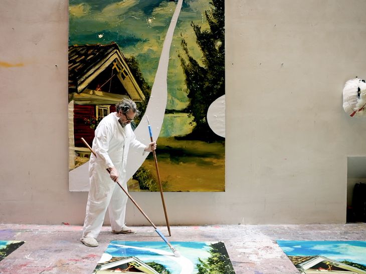 Julian Schnabel painting using a long, broom-like paintbrush