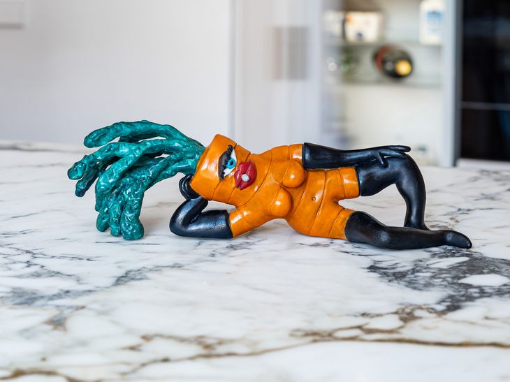 painted bronze carrot reclining seductively on a white marble countertop