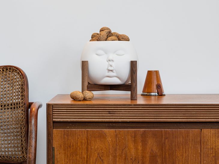 ceramic sculpture filled with walnuts on teak sideboard