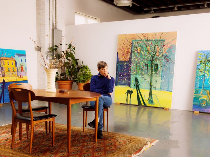 Deborah Brown sat in her studio in front of several large and colourful paintings