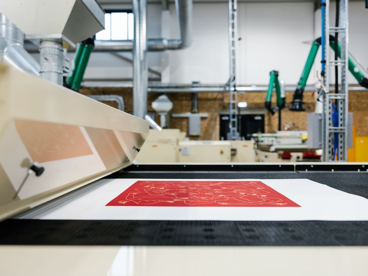 red print moving through a drying machine on a conveyor belt