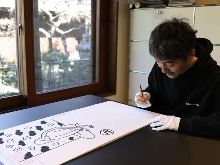 Yu Nagaba signing a print edition in his studio