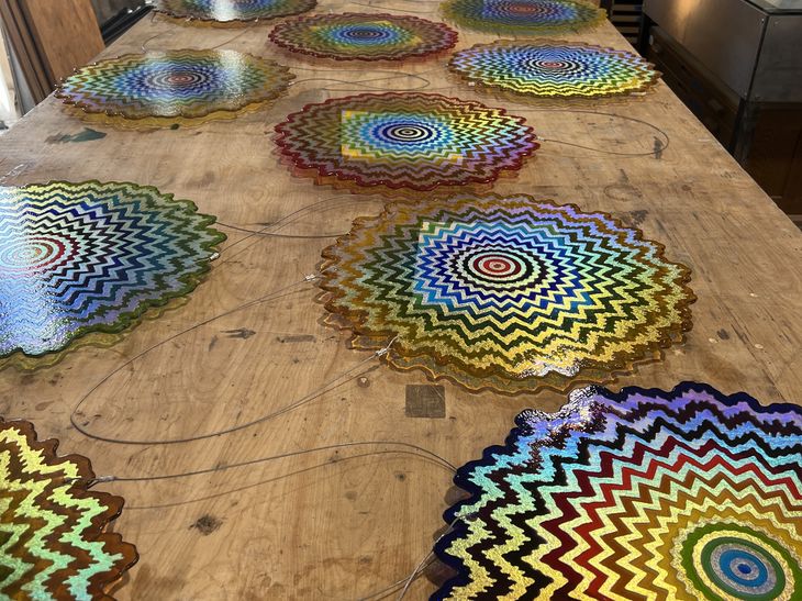a row of rainbow mandalas by Jen Stark in a production studio 