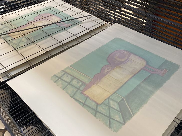 Clayton Schiff prints on a printing rack in a studio