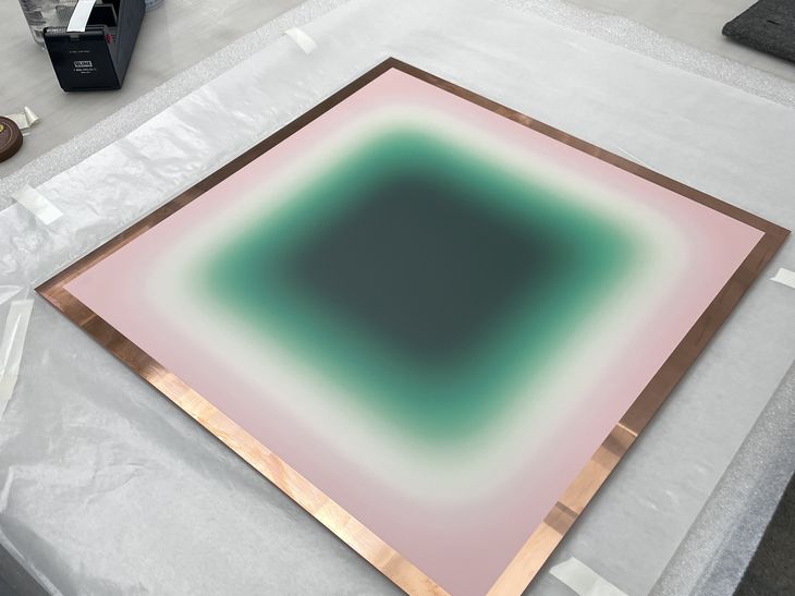 a print edition by Jonny Niesche laid on bubble wrap and in a bronze frame