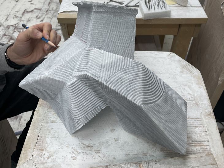 a grey marble sculpture being detailed in pencil