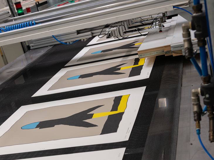 row of half-printed silkscreen prints in a workshop