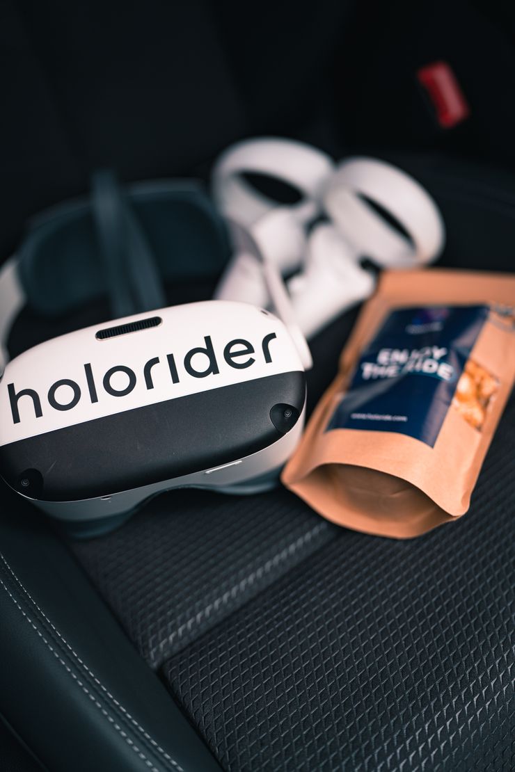 VR headset with holoride lettering and popcorn package on a car seat