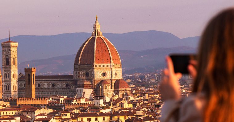 woman taking a photo of the duomo in florence, italy