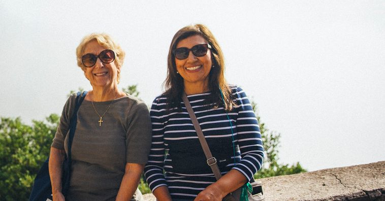 two women with sunglasses smiling at camera
