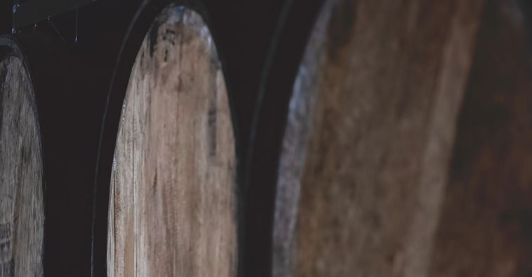 whisky barrels lined up in distillery
