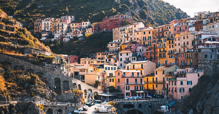 yellow and orange pastel houses along the coast in cinque terre italy