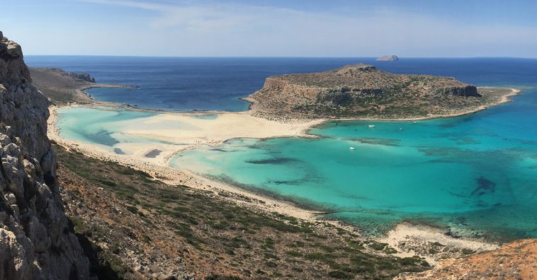 rocky cliff surrounding beach in crete greece