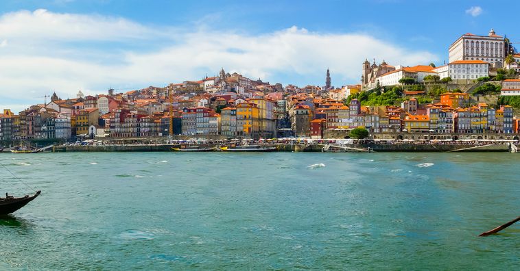 boats docked in front of colorful buildings along the douro river in porto portugal