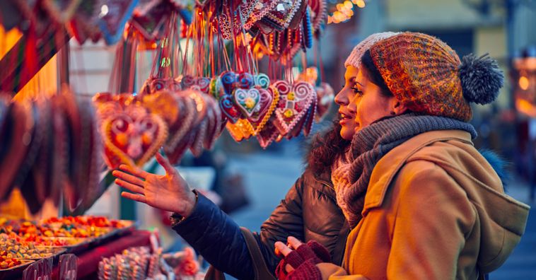 women looking at christmas ornaments at an outdoor market