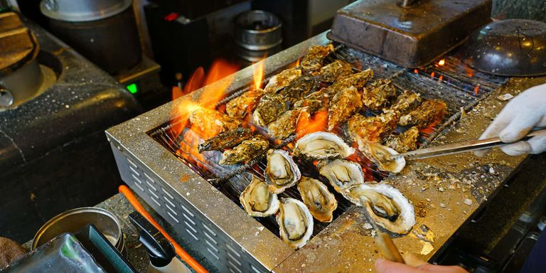 Oysters being grilled in a restaurant on Miyajima Island, Japan