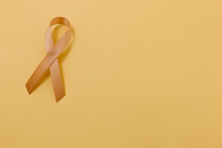 A yellow cancer ribbon on a yellow background
