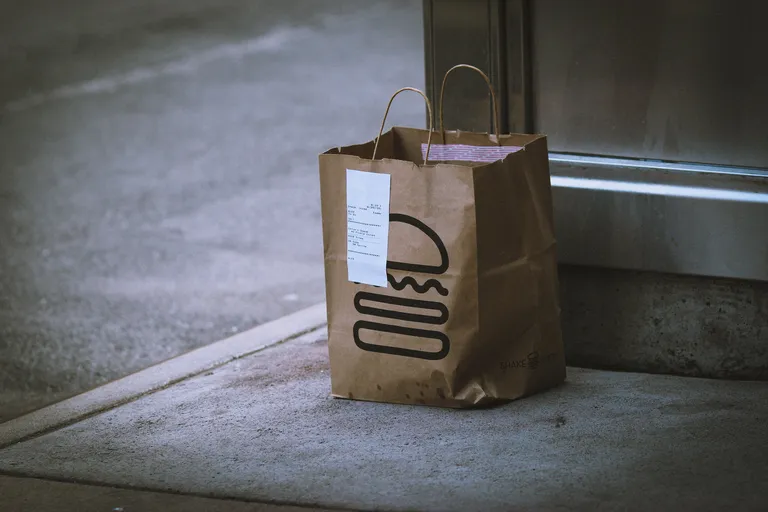 A brown paper delivery bag at a doorstep