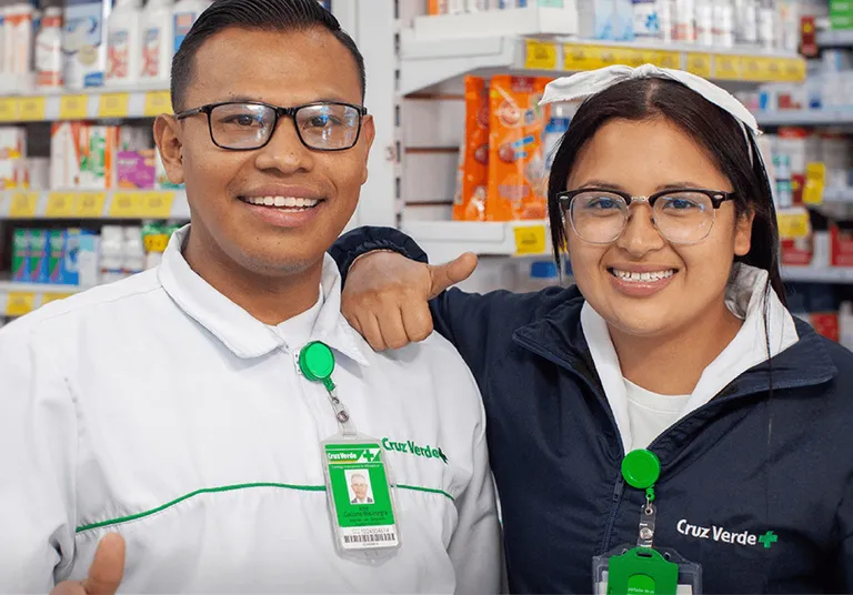 Two Cruz Verde pharmacists smile at the camera