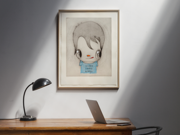Print by Javier Calleja hanging on a wall by a desk