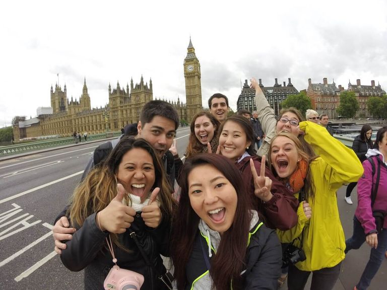 A group of travelers in London with the Big Ben clocktower behind them.